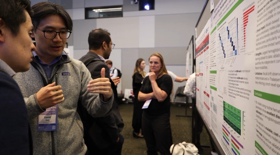 David discussing his hemoglobinopathy poster with attendees at Stanford AIMI